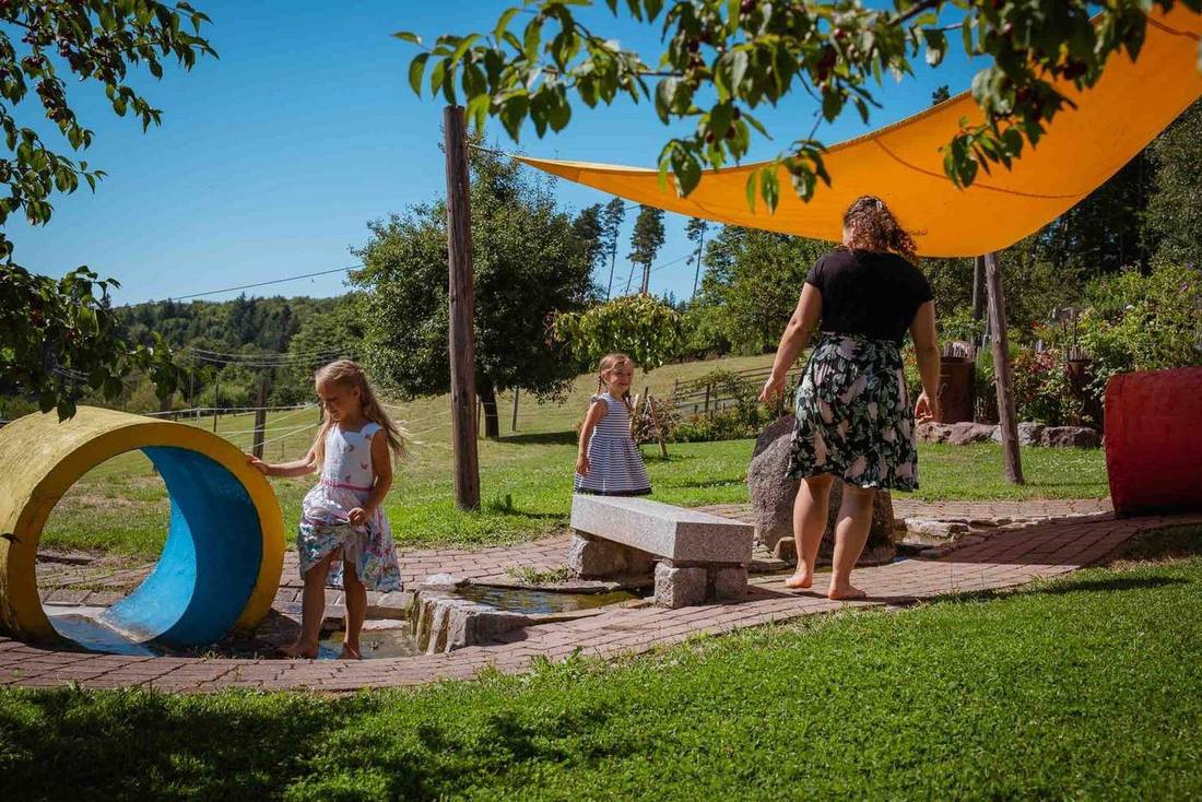 Kinder mit Mama am Wasserspielplatz des Grub-Daniel-Hofs