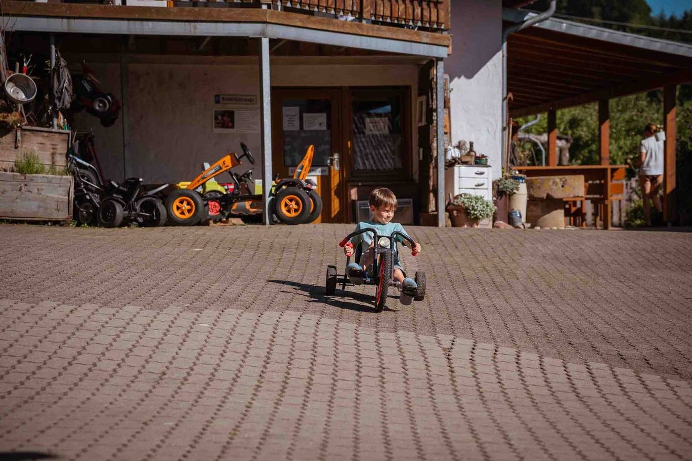 Kind fährt mit dem Trike auf dem Grub-Daniel-Hof