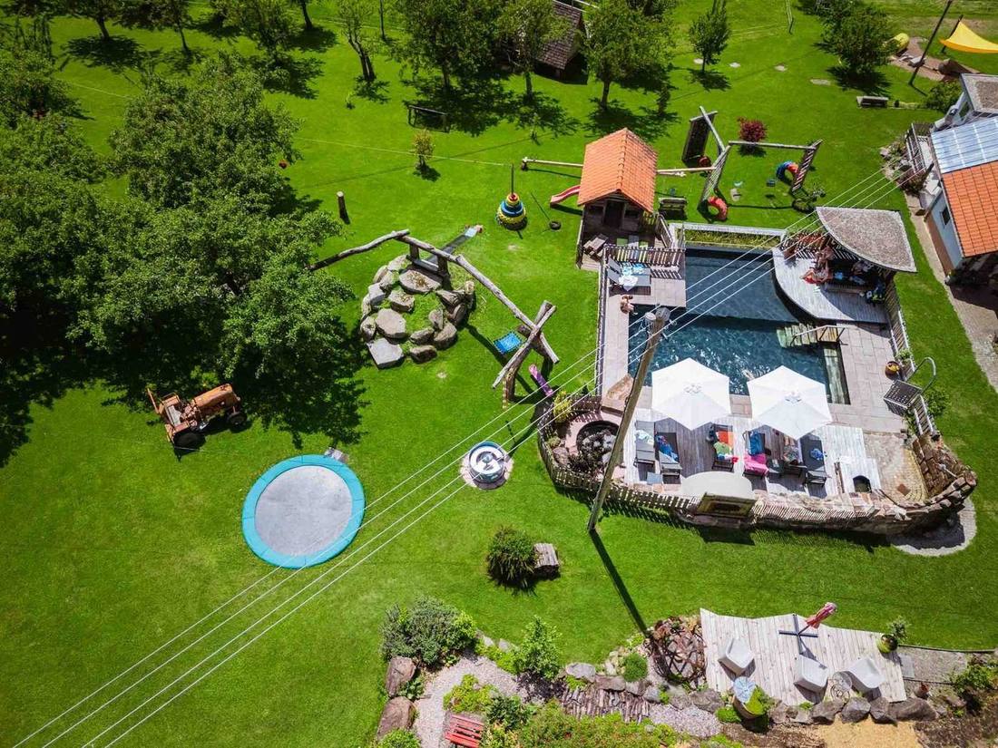 Naturpool und Spielplatz aus der Vogelperspektive